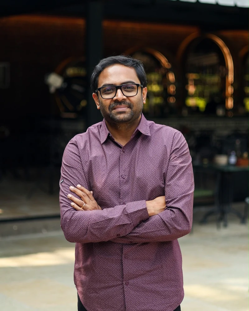 Gopichand Cherukuri of ICB, standing in the courtyard with arms folded