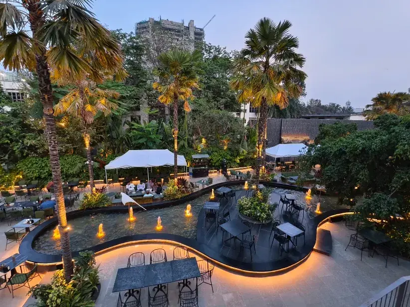 Nir, the garden of happiness at dusk: palms, cabanas and a curved water channel lit from below
